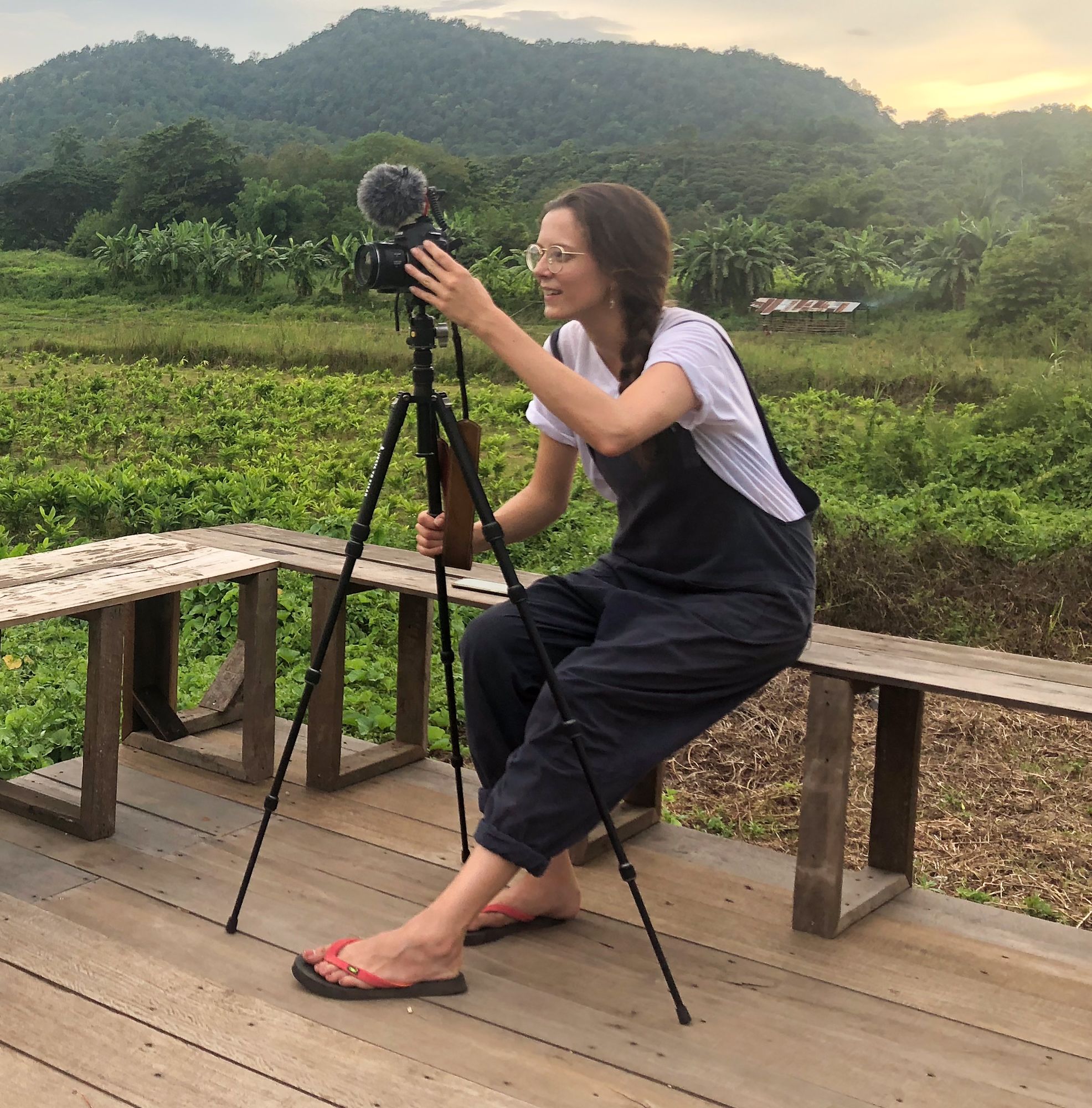 A photo of Anne operating camera in the Thai countryside