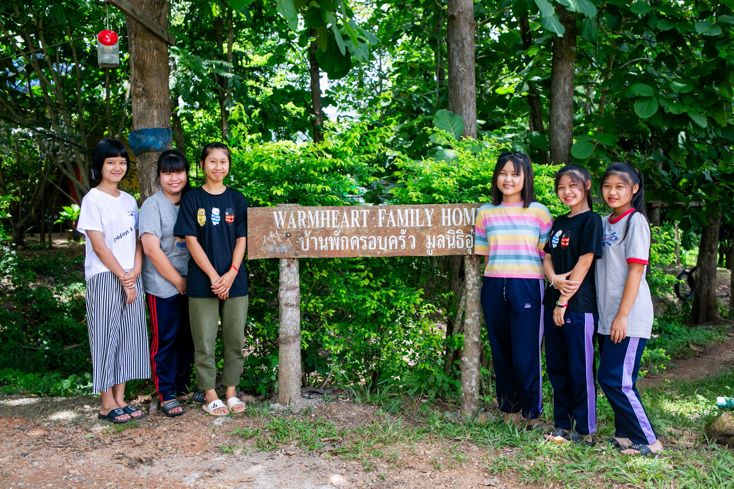 A group of high school girls pose with the Warm Heart welcome sign